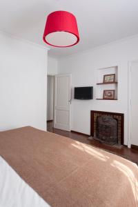 1 dormitorio con chimenea y lámpara roja en La Petite Maison San Isidro en San Isidro