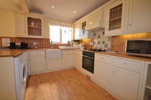 a kitchen with white cabinets and a stove top oven at 4 Brooks Close in Bembridge