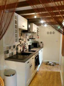 a kitchen with white cabinets and a sink at Brecon Boutique Breaks Wild Land in Sennybridge