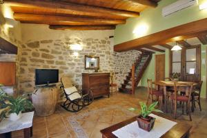 sala de estar con TV, mesa y sillas en Apartamentos Santa Agueda, en Valderrobres