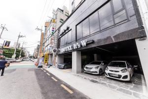 two cars parked in the garage of a car dealership at It's W in Suwon