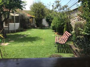 a park bench sitting in the yard of a garden at Cozy Room in La Paz