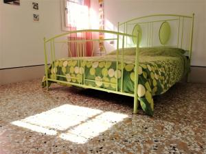 een slaapkamer met een bed met een groene sprei bij A CASA DI PEPLIS in Venetië