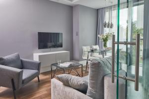 Rydygiera 16-18 by Homeprime في وارسو: غرفة معيشة مع أريكة وتلفزيون