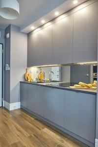 a large kitchen with white cabinets and a wooden floor at Rydygiera 16-18 by Homeprime in Warsaw