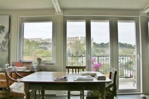 a dining room with a table and some windows at Mini Attico panoramico con terrazza in Cagliari