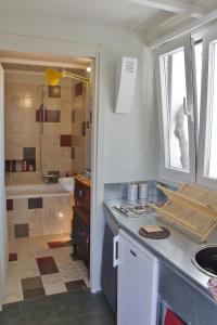 una cucina con lavandino e un bagno con vasca di Mini Attico panoramico con terrazza a Cagliari