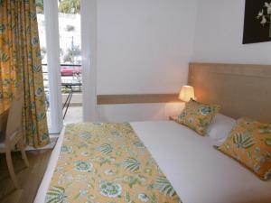 1 dormitorio con cama y ventana en Hôtel La Flore en Villefranche-sur-Mer