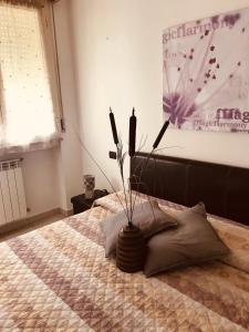 een slaapkamer met een bed met een vaas erop bij Residence Mariele in Tavazzano