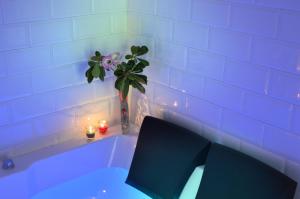 a white tub with a vase of flowers and a chair at Barbarella Home in Naples