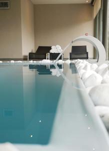 een kamer met een zwembad met een tafel en stoelen bij Logis Hotel Restaurant A L'Etoile in Mittelhausen