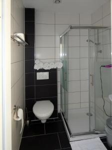 een badkamer met een toilet en een glazen douche bij Hotel Wolters in Bremen