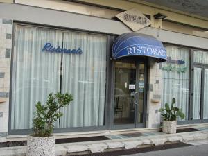a store front of a restaurant with a blue awning at Hotel Kroma in Ragusa