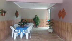 comedor con mesa azul y sillas blancas en Casa em Arraial / Monte Alto, en Arraial do Cabo