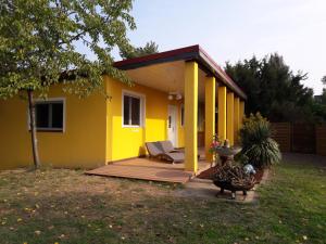 a small yellow house with a porch and a yard at Bungalow at Lake Alte Donau in Vienna