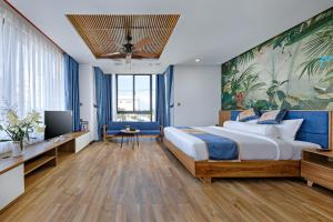 a hotel room with a large bed and a tv at Animor Green Home Villa Da Nang in Danang