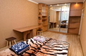 a bedroom with a bed and a desk and a mirror at Апартаменты Deluxe in Cherkasy