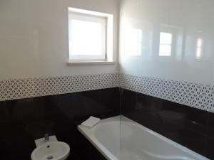 a bathroom with a sink and a tub and a toilet at T2 Baleal in Peniche