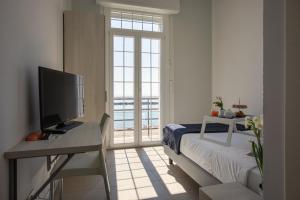 a bedroom with a desk with a television and a bed at Casa F.A.C.I in Marina di Massa