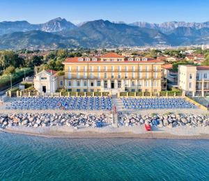 a building with a beach with umbrellas and the water at Casa F.A.C.I in Marina di Massa