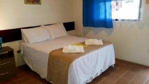 um quarto com uma cama com duas toalhas em Pousada Via Maria em Cananeia