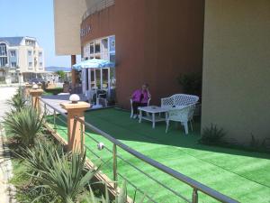 a woman sitting at a table on a patio at Hotel Venecia in Primorsko