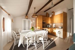 uma sala de jantar com uma mesa branca e cadeiras em Casa do Mar | Sea House | Apúlia em Apúlia