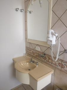 y baño con lavabo y espejo. en Sítio Hotel e Eventos, en Sao Pedro do Sul