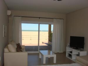 een woonkamer met uitzicht op het strand bij Apart en la Playa Mar de las Pampas in Mar de las Pampas