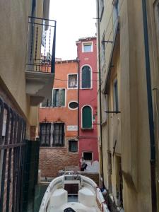 a boat in an alley between two buildings at Bell Tower House in Venice