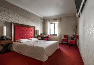 a bedroom with a bed with a red headboard and red carpet at Vanilla Hotel in Lublin