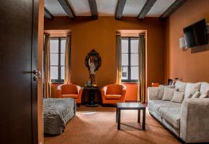a living room with a couch and orange chairs at Vanilla Hotel in Lublin