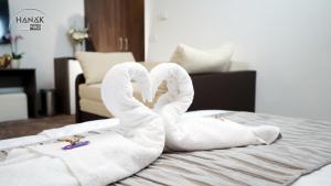 two towels shaped like swans sitting on a bed at Hotel Írisz in Nyíregyháza