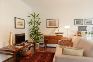 a living room with a couch and a tv at Porto D´Ouro Apartments in Porto