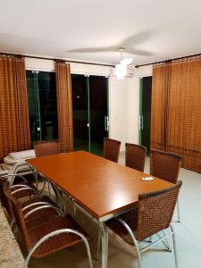 a conference room with a wooden table and chairs at Cobertura Jacuzzi Vista Mar in Bombinhas +33 photos