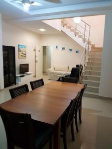 comedor con mesa, sillas y escaleras en Cobertura Jacuzzi Vista Mar, en Bombinhas