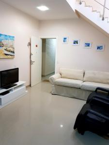 a living room with a couch and a tv at Cobertura Jacuzzi Vista Mar in Bombinhas