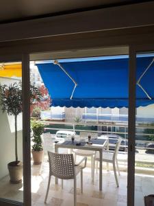a patio with a table and a blue umbrella at Palm beach Cannes Azur in Cannes