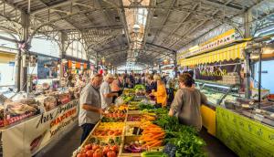 eine Gruppe von Menschen, die auf einem Markt mit Obst und Gemüse stehen in der Unterkunft DUPLEX FONTAINE - Appartement Duplex coeur vieil Antibes Old city Marché provencal in Antibes