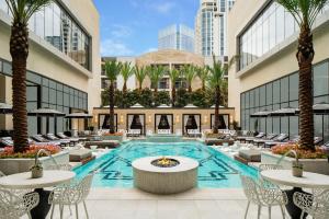 a large swimming pool with tables and chairs in front of it at The Post Oak Hotel in Houston