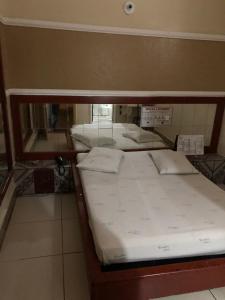 uma cama num quarto com um espelho em Motel Coimbra (Adults only) em Belo Horizonte