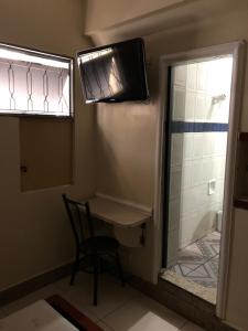 a small bathroom with a table and a shower at Motel Coimbra (Adults only) in Belo Horizonte