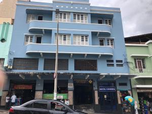 a blue building with a car parked in front of it at Motel Coimbra (Adults only) in Belo Horizonte