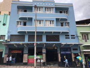 a blue building with people walking in front of it at Motel Coimbra (Adults only) in Belo Horizonte