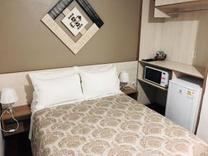 a hotel room with a bed and a tv at Hotel Westphal in Pelotas