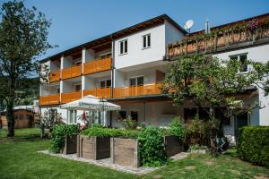 ein Apartmenthaus mit einem Garten davor in der Unterkunft Gasthof Weißes Rössl in Mühldorf