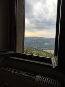 una ventana con vistas al campo a través de ella en House in Central Todi with Sensational Views of Surrounding Countryside, en Todi