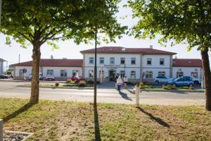 a woman walking in front of a white building at Bahnhof-Erzingen, hotel, coffee & more in Erzingen