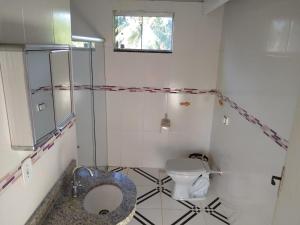 baño pequeño con aseo y ventana en Apartamento Cumuru en Cumuruxatiba