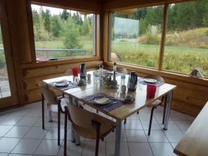 a dining room with a table and some windows at Little Black Bear Lodge/B&B in Bridge Lake